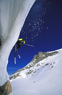 A skier hucks off of a cliff while backcounrty skiing near Tuolumne Meadows, California.