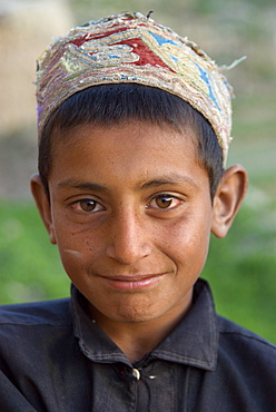 A young boy smiles shyly  in the Tajik village of Dera Jawal, at the base of the Band-e Baba range,  Herat Province, Afghanistan