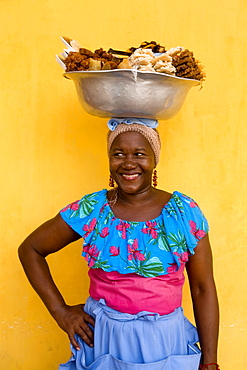 A "Palanquera" sells sweets from a large metal bowl she carries on her head  in Cartagena, Colombia in August 2007.