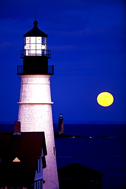 The full moon rises near the Portland Headlight on December 22, 1999 in Cape Elizabeth, Maine.