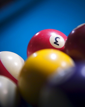 Close up of colored billiard balls on felt table.