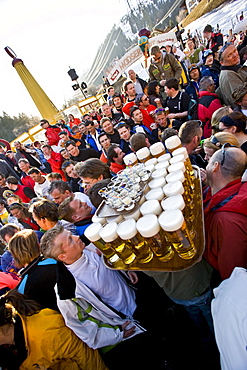 A waiter carries thirty nine and half liters of beer and a tray of shots through a crowd at the Mooserwirt apres-ski ar in St. Anton am Arlberg, Austria.