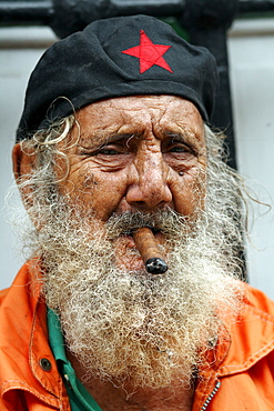 A man with a cigar poses for a portrait near the Plazas de Armas in Havana, Cuba.