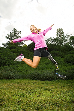 Sarah Reinertsen, the first female amputee to complete the Ironman Triathlon World Championship, jumps in the air for a portrait in Carlsbad, California.