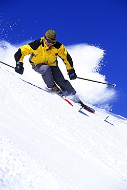 Man downhill skiing in Utah on a sunny day.