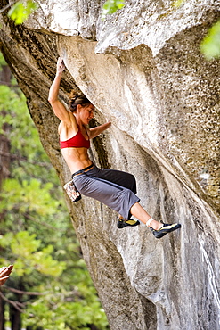 A female rock climber bouldering in Yosemite National Park.