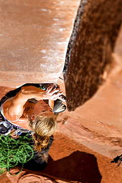 A female rock climber climbs Ruby's Cafe, a classic 5.13 rated climb in Indian Creek, Utah.