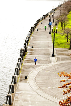 An athletic female in a blue jacket jogging near the Portland, Oregon waterfront.