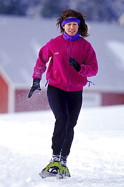 Meril Cray jogs past a barn near Cray's home in Middlesex VT. Cray, an avid jogger during the summer is one of the many people across the country who have taken on the sport of snowshoe running.