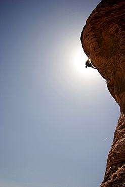 A rock climber ascends a red rock face in Nevada.