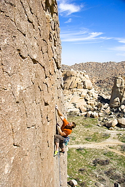 A rock climber climbs a vertical sport route in the Valley of the Moon in Southern California on the Mexico border.