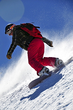 A female snowboarder rides some powder in the Kirkwood backcountry, CA.