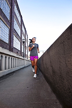 A teenage girl runs on the sidewalk of a bridge in downtown Birmingham, Alabama.