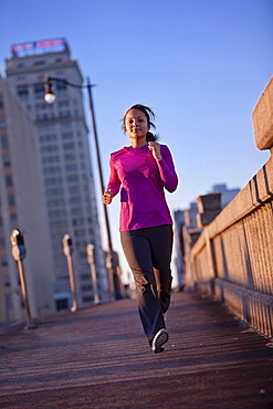 A teenage girl runs on a sidewalk at dusk in downtown Birmingham, Alabama.