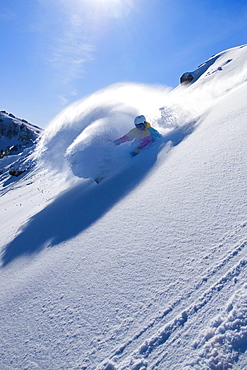 A man skiing powder snow at a ski resort in the Sierra mountains of California