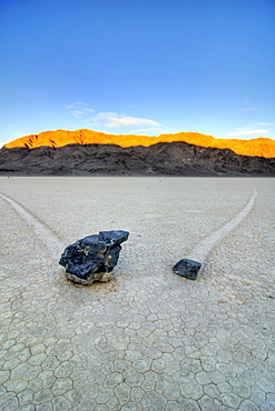 Two rocks leave trails of their movement on The Racetrack in Death Valley National Park at sunrise, California.