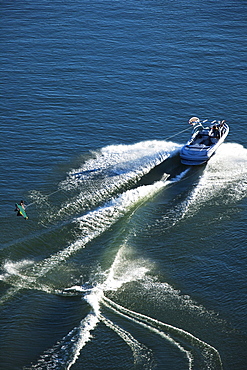 A athletic wakeboarder jumps the wake going huge on a calm day in Idaho.