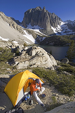 Man cooks outside tent .