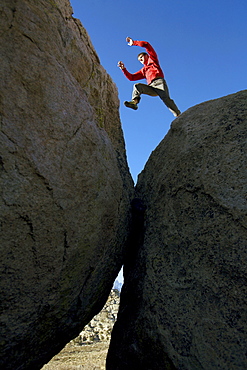 Man jumping across boulders