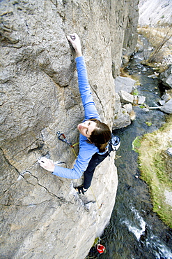 Two people climbing above river