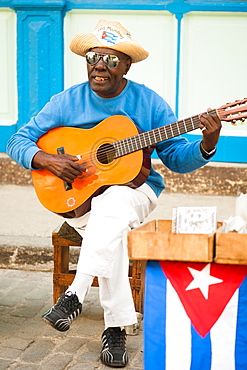 A street musician in Havana, Cuba sings and sells CDs of his music.