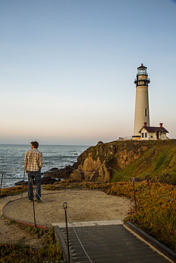 A man enjoys the dusk views at the Pigeon Point Lighthouse near Pescadero, California on a sunny day, Pescadero, California, USA