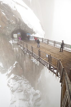 Visitors cross a bridge on the lower platforms at the Aiguille du Midi, Mont Blanc Massif, French Alps.