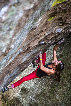 Strong Female bouldering on overhanging rock in Idaho