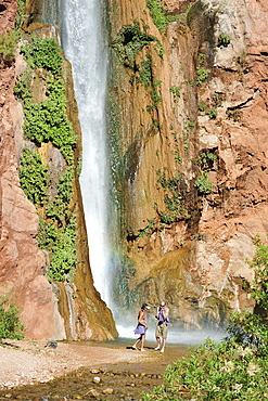 Hikers swim in the pool below 180-foot Deer Creek Falls in the Grand Canyon outside of Fredonia, Arizona November 2011.  The 21.4-mile loop starts at the Bill Hall trailhead on the North Rim and descends 2000-feet in 2.5-miles through Coconino Sandstone to the level Esplanada then descends further into the lower canyon through a break in the 400-foot-tall Redwall to access Surprise Valley.  Hikers connect Thunder River and Tapeats Creek to a route along the Colorado River and climb out Deer Creek.