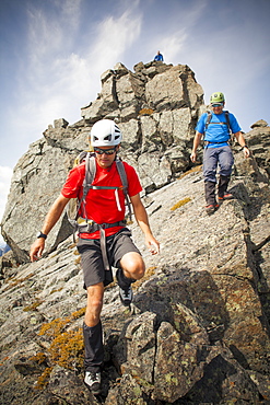 Three climbers descend from the summit of Trio Peak, British Columbia, Canada.