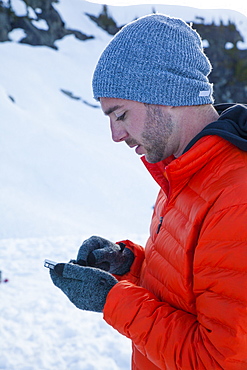 A climber checks his e-mail on his smartphone while camping in the mountains of British Columbia, Canada.