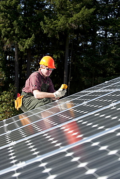 A technician measures the electricity generated by a photovoltaic panel, United States of America