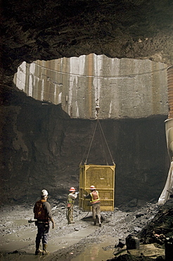 Workers exiting tunnel in crane cage, United States of America