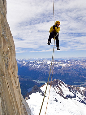 A climber rappels down Cerro Fitz Roy's south face, with distant peaks and lakes of Argentine Patagonia in the distance. Cerro Fitz Roy is one of the most massive peaks in the Southern Andes, and is a sought after summit by the world's top alpinists. It was named in honor of the captain of Darwin's ship, the Beagle, Captain Robert FitzRoy, who explored the region. The indigenous name for the peak is Chalten, which means "smoking mountain". , Argentina