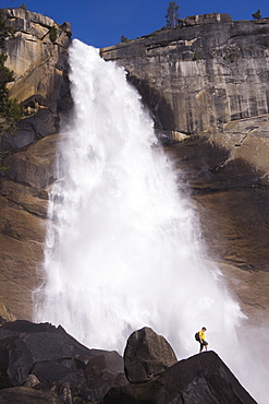 A man hiking in Yosemite National Park by Nevada Falls in California.