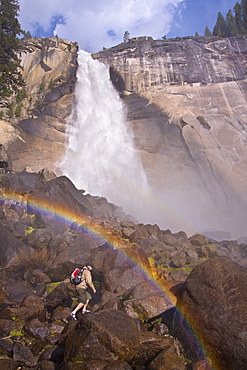 A man hiking in Yosemite National Park by Nevada Falls in California.