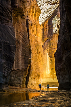 Two people hiking in a canyon.