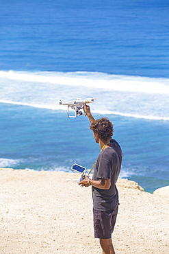 Man with controlled drone on the beach