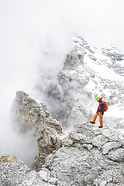 The Italian Guide Standing On Exposed Ridge Near The Summit Of Punta Anna