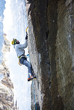 Male Climber Ice Climbing In Ceresole Reale Ice Park, Piemonte, Italy