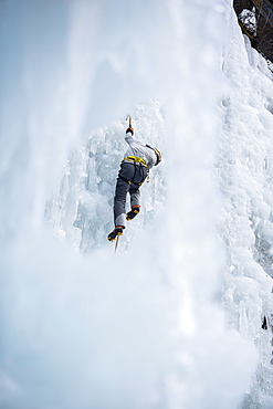 Male Climber Ice Climbing In Ceresole Reale Ice Park, Piemonte, Italy