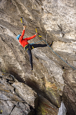 Male Ice Climber Climbing And Drytooling On Rock