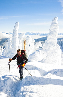 Male Skier Hiking On Snowy Landscape In Whitefish, Montana, Usa