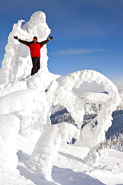 Male Snowboarder Standing On Snow Shaped Ghost At Whitefish, Montana, Usa