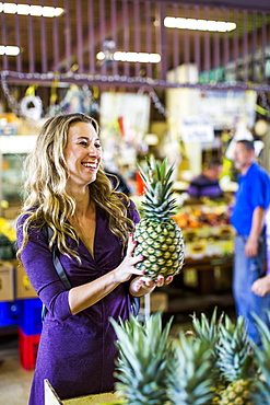 A Young Woman Buying Pineapple At A Market In Old San Juan, Puerto Rico