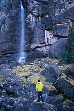 Young male stands at the base of Bridal Veil Falls in Telluride Colorado