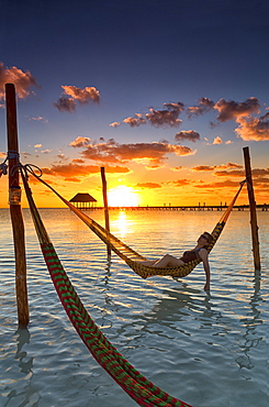 Woman lying in hammock at sunset, Holbox Island, Cancun, Yucatan, Mexico