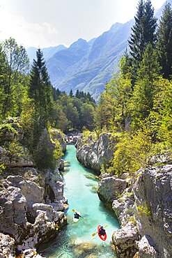 Kayakers on Soca river originating in Trigval mountains. The river is famous for all kinds of white water activities, Triglav National Park, Slovenia