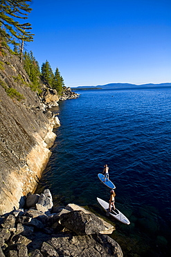 Man and woman paddleboarding near seashore, D.L. Bliss State Park, California, USA