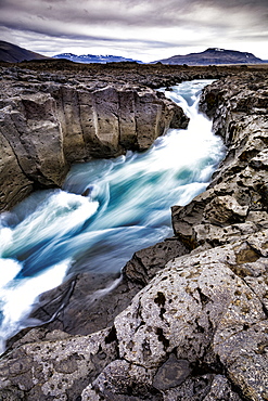 Scenic landscape of glacial meltwater running through andesite lava river channel in highlands of Iceland